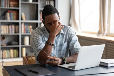 tired black man at laptop