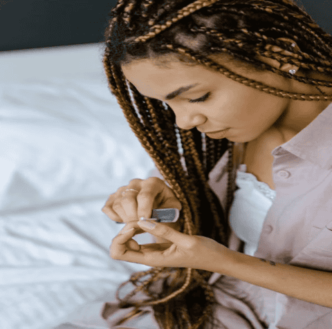 Woman examining her dark lines on nails.