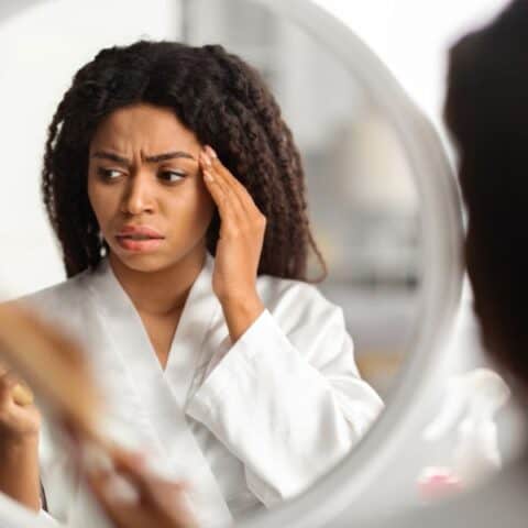 Woman holding a comb in hand experiencing hair loss