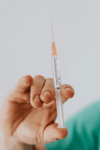 Hand holding syringe