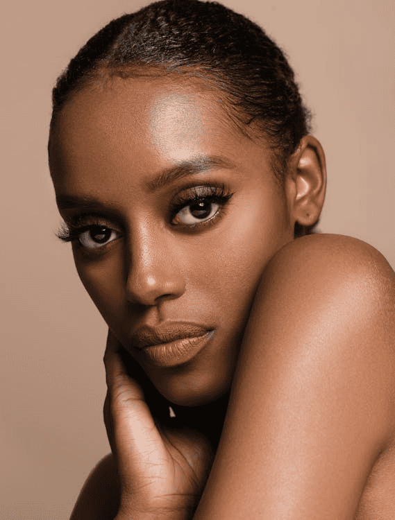 Individual looking straight ahead in front of light brown backdrop