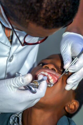 black dentist near me showing a black dentist and black boy patient